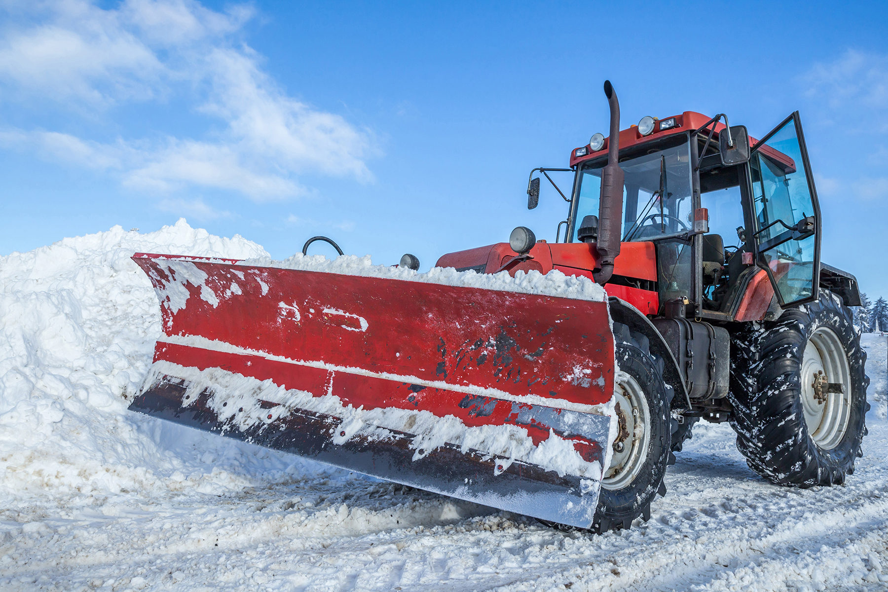 Large tractor with a plow on the front, clearing snow