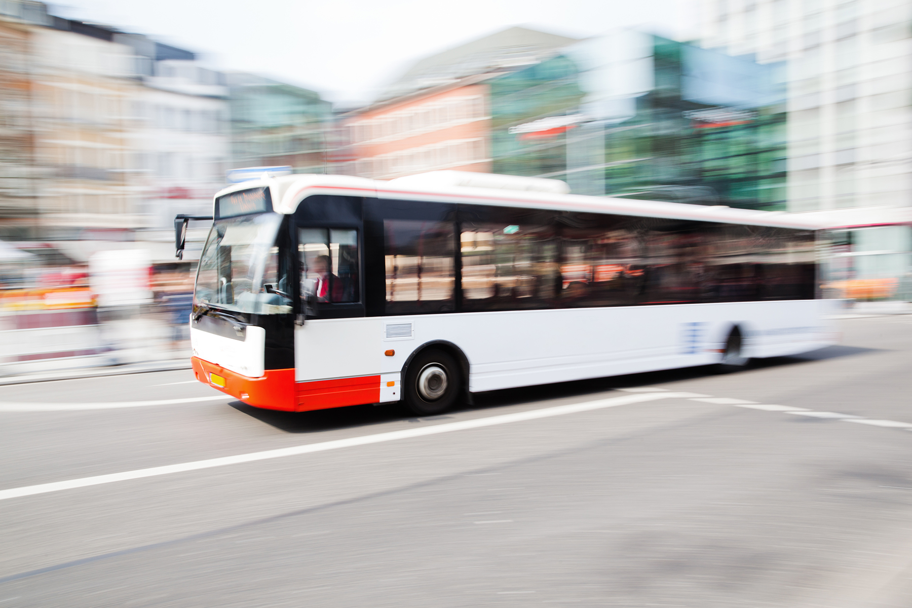 City bus on a street with buildings in the background